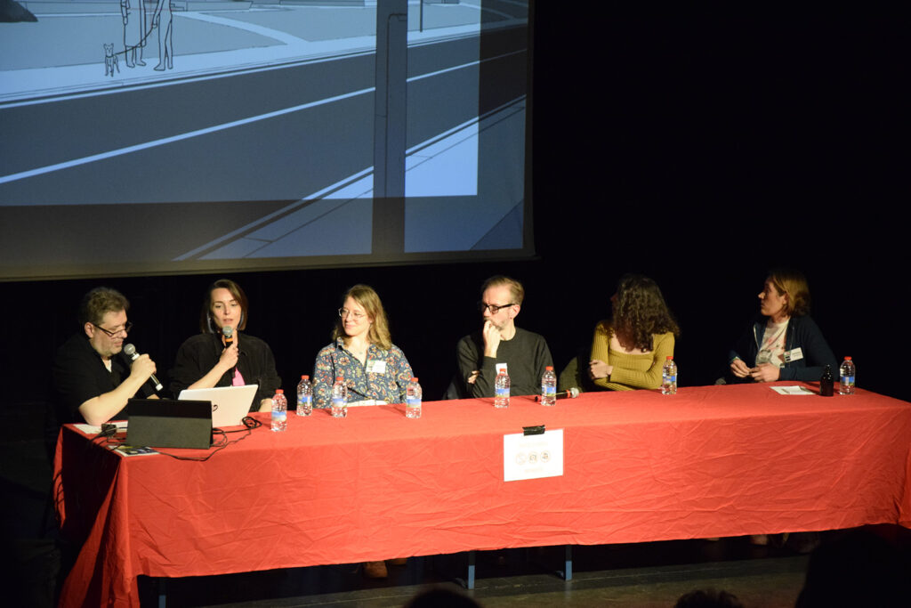 Les participants et participantes de la conférence Mars Express : Alex PILOT Anne RAFFIN Anaïs MIRLIAZ Jérémie PÉRIN Marion ROUSSEL Fanny BRICOTEAU sont sur la scène des conférences. Alex et Anne ont un micro dans la main et ils expliquent le travail de layout posing sur le film.